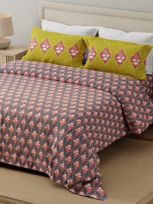 Bed with patterned bedding and green pillows in a bedroom setting