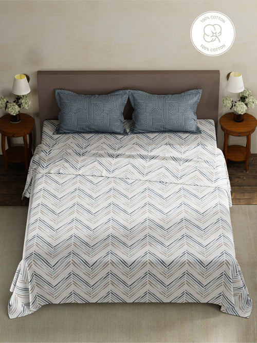 Bed with zigzag patterned comforter and matching pillows in a bedroom setting.