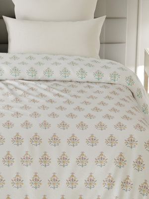 Floral patterned bedspread on a bed with white pillows.