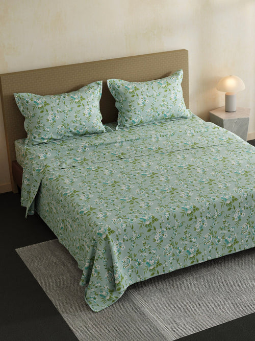 Floral patterned bedspread on a bed with matching pillows in a bedroom setting.