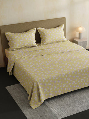 Yellow floral patterned bedspread on a bed in a bedroom setting